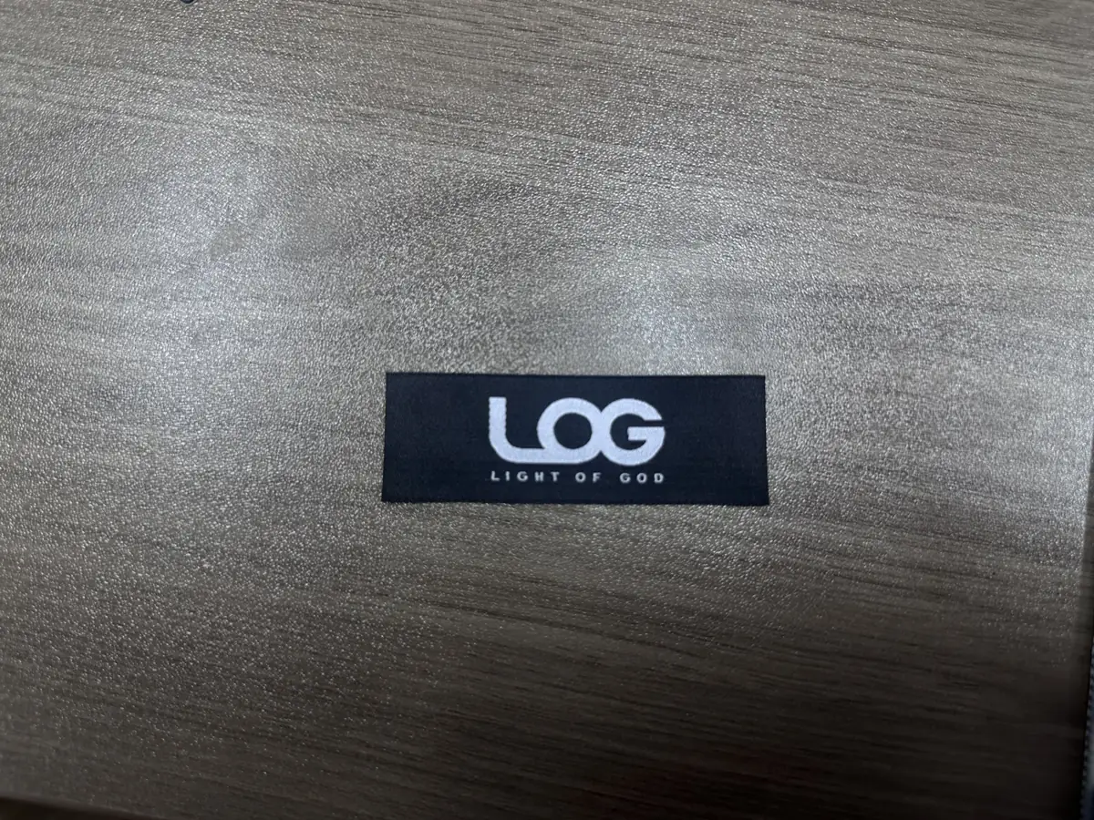 Black fabric brand label with white logo and lettering